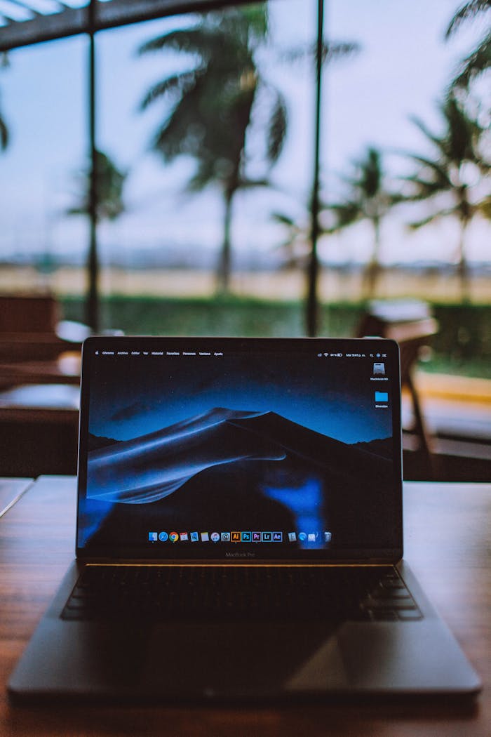 why-choose-us A sleek laptop on a wooden desk with a tropical view behind, ideal for remote work and travel themes.